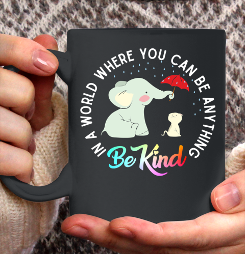 In a world where you can be anything be kind Elephant holding un umbrella to protect Cat form Rain Autism Awareness Ceramic Mug 11oz